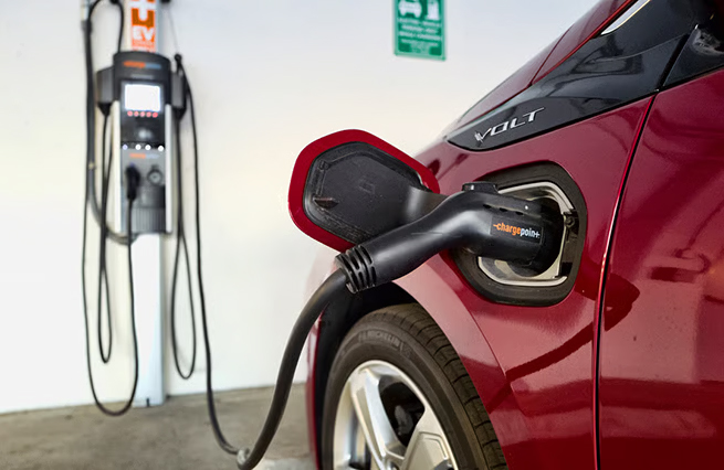 Red EV plugged into a Level 2 charger